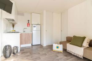 a living room with a couch and a kitchen at Club del Sole Rimini Family Resort in Rimini