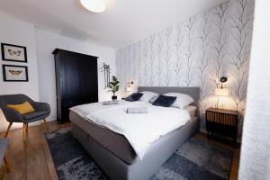 una camera con un grande letto bianco e una sedia di Racing-Apartment (Ferienwohnung) a Herresbach