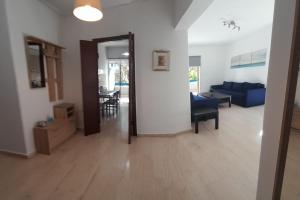 - un salon avec un canapé bleu et une table dans l'établissement Loveliest Place At AthensRiviera, à Vari