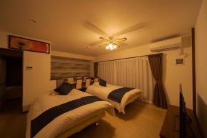 1 dormitorio con 2 camas y ventilador de techo en Tabi no yado Hanakeshiki Botan 4th floor - Vacation STAY 43035v, en Yufu
