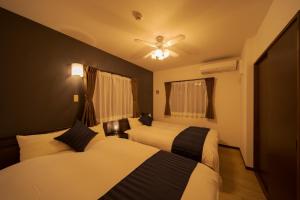 1 dormitorio con 2 camas y ventilador de techo en Tabi no yado Hanakeshiki Sakura 2nd floor - Vacation STAY 42969v en Yufuin