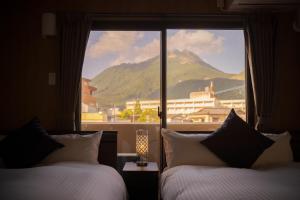 a hotel room with two beds and a large window at Tabi no yado Hanakeshiki Momo 4th floor - Vacation STAY 42997v in Yufuin