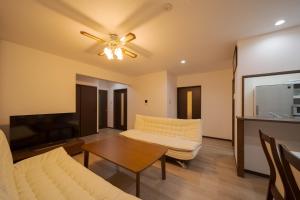 uma sala de estar com um sofá e uma mesa em Tabi no yado Hanakeshiki Momo 4th floor - Vacation STAY 42997v em Yufu