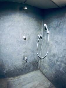 a bathroom with a shower in a wall at Ostello Surf Resort in Ahangama