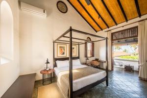 Nyne Hotels - The Muse, Bentota في بينتوتا: غرفة نوم مع سرير المظلة ومكتب