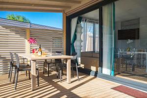 a dining room with a table and chairs on a deck at Club del Sole Rimini Family Resort in Rimini