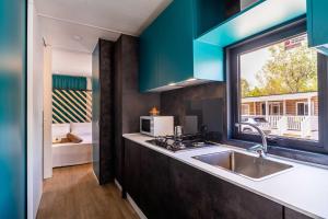 a kitchen with a sink and a window at Club del Sole Rimini Family Resort in Rimini