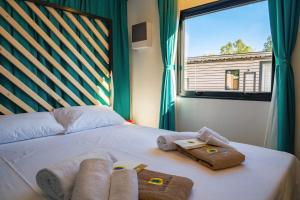 a bedroom with a bed with towels and a window at Club del Sole Rimini Family Resort in Rimini