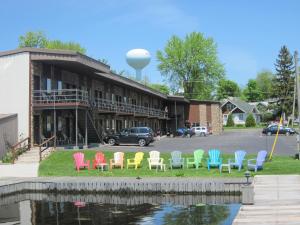un groupe de chaises colorées devant un bâtiment dans l'établissement Otter Creek Inn, à Alexandria Bay