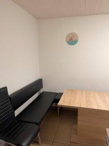 een kamer met een bank, een tafel en een klok bij Unterkunft Heidenheim - kostenfreie Parkplätze, WLAN, eigene Küche, große Zimmer in Heidenheim an der Brenz