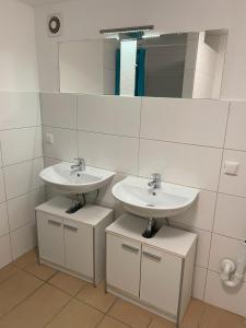 een badkamer met 2 wastafels en een spiegel bij Unterkunft Heidenheim - kostenfreie Parkplätze, WLAN, eigene Küche, große Zimmer in Heidenheim an der Brenz