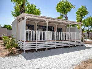 a small white shed with a white fence at Club del Sole Rimini Family Resort in Rimini