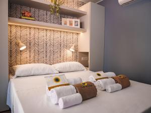 a bedroom with a white bed with towels on it at Club del Sole Rimini Family Resort in Rimini