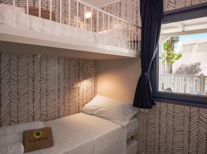 a bedroom with two bunk beds and a window at Club del Sole Rimini Family Resort in Rimini