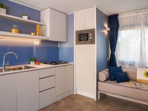 a small kitchen with white cabinets and a sink at Club del Sole Rimini Family Resort in Rimini