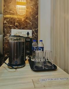 a coffee maker and glasses on a table at Hotel Small Daddy Plus in Calangute