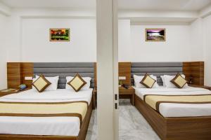 two beds in a hotel room with two beds at Hotel S B INN Paharganj in New Delhi