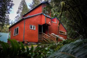una casa roja con techo rojo en Little Haven Cottage, en Glacier