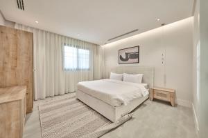 una camera bianca con un letto e una finestra di Mabaat - Al Nakheel - 546 a Riyad