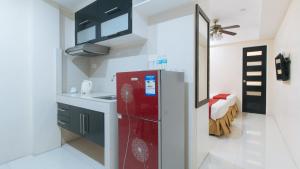 uma cozinha com um frigorífico vermelho num quarto em RedDoorz at Grand Apartelle Hernan Cortes Cebu em Cebu