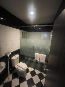 ein Bad mit einem WC und einem Waschbecken in der Unterkunft GRAND DARUSSALAM HOTEL in Medan