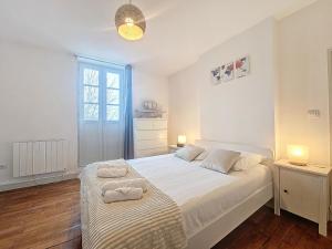 een slaapkamer met een groot bed en handdoeken bij Le Régemortes, centre ville et proche du CNCS, avec services premium by PRIMO C0NCIERGERIE in Moulins
