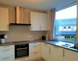 une cuisine avec des placards blancs et une grande fenêtre dans l'établissement fewo1846 - Kranich - komfortable Wohnung mit 2 Schlafzimmern im Erdgeschoß, à Flensbourg