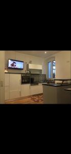 een keuken met een flatscreen-tv aan de muur bij Zum Bürgerhof „Selina“ in Saarlouis