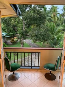 2 chaises assises sur un balcon avec une fenêtre dans l'établissement Mohotti House, à Galle