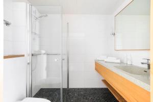 a bathroom with a glass shower and a sink at Original Sokos Hotel Tapiola Garden Espoo in Espoo