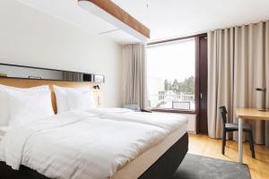 um quarto de hotel com uma cama grande e uma secretária em Original Sokos Hotel Tapiola Garden Espoo em Espoo