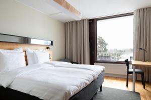 a hotel room with a bed and a large window at Original Sokos Hotel Tapiola Garden Espoo in Espoo