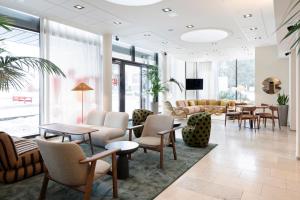 a lobby with tables and chairs and a waiting room at Original Sokos Hotel Tapiola Garden Espoo in Espoo
