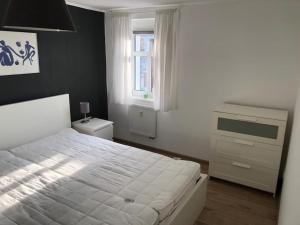 a bedroom with a bed and a dresser and a window at Gemütliche Kleine Wohnung in Wendelstein