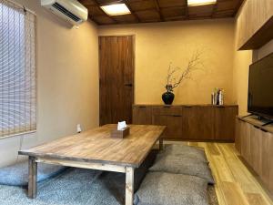 salon z drewnianym stołem i telewizorem w obiekcie 満竹華庵 manchikan w Tokio