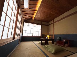 Pokój z oknami, stołem i łóżkiem w obiekcie 満竹華庵 manchikan w Tokio
