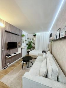 a living room with a couch and a tv at Appartement proche stade de France et métro 12 in Saint-Denis