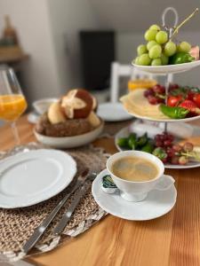 uma mesa com pratos de comida e uma chávena de café em Mia’sFerienwohnung/Monteurwohnung em Herborn