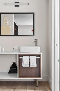 a bathroom with a sink and a mirror at Developer Inn Highway, A Howard Johnson by Wyndham in Kissimmee