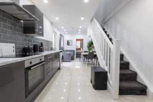 a kitchen with a staircase leading to a living room at WiFi | Garden | 2BR in Cardiff