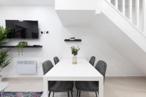 a white dining room with a white table and chairs at WiFi | Garden | 2BR in Cardiff