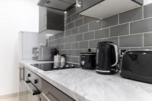 a kitchen with a counter top with a toaster and a appliance at WiFi | Garden | 2BR in Cardiff