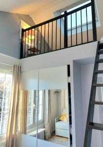 a loft bed in a room with a mirror at Chambre avec mezzanine dans une maison d'artiste in Rueil-Malmaison