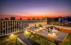 a table on a balcony with a view of the city at Cozy 2BR Loft in the Heart of Miraflores in Lima