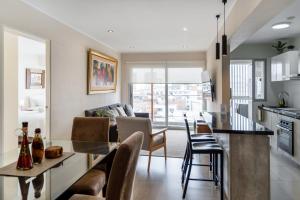 cocina y sala de estar con mesa y sillas en Modern 1BR Loft close to the seawalk of Miraflores en Lima