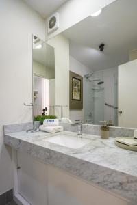 a bathroom with a sink and a large mirror at Modern 1BR Loft close to the seawalk of Miraflores in Lima