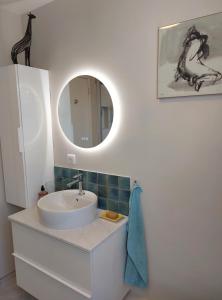 La salle de bains est pourvue d'un lavabo et d'un miroir. dans l'établissement Chambre avec mezzanine dans une maison d'artiste, à Rueil-Malmaison