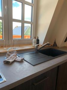a kitchen counter with a sink and two wine glasses at Ferienhaus Mühle "Neue Hoffnung" in Beidenfleth