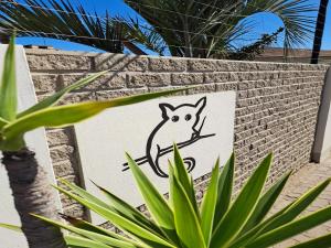 un cartello con un gatto su un muro di mattoni di Bushbabies-Inn Self-Catering Accommodation a Swakopmund