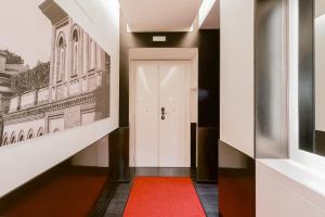 un corridoio con una porta bianca e un tappeto rosso di Roma Centro CDR Luxury Suites a Roma Altre 44 foto